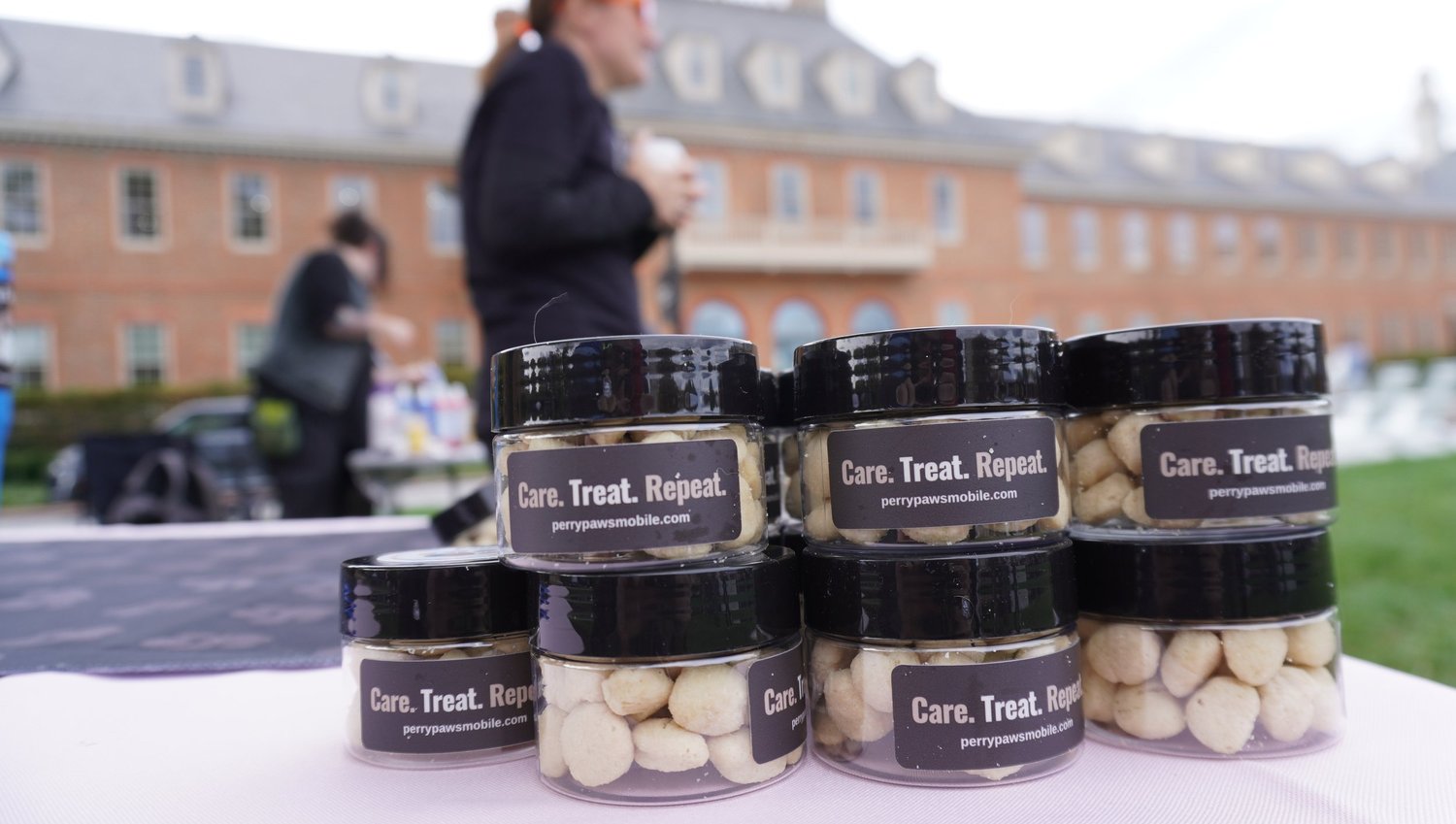 Jars of pet treats on a Perry Paws Mobile community event table