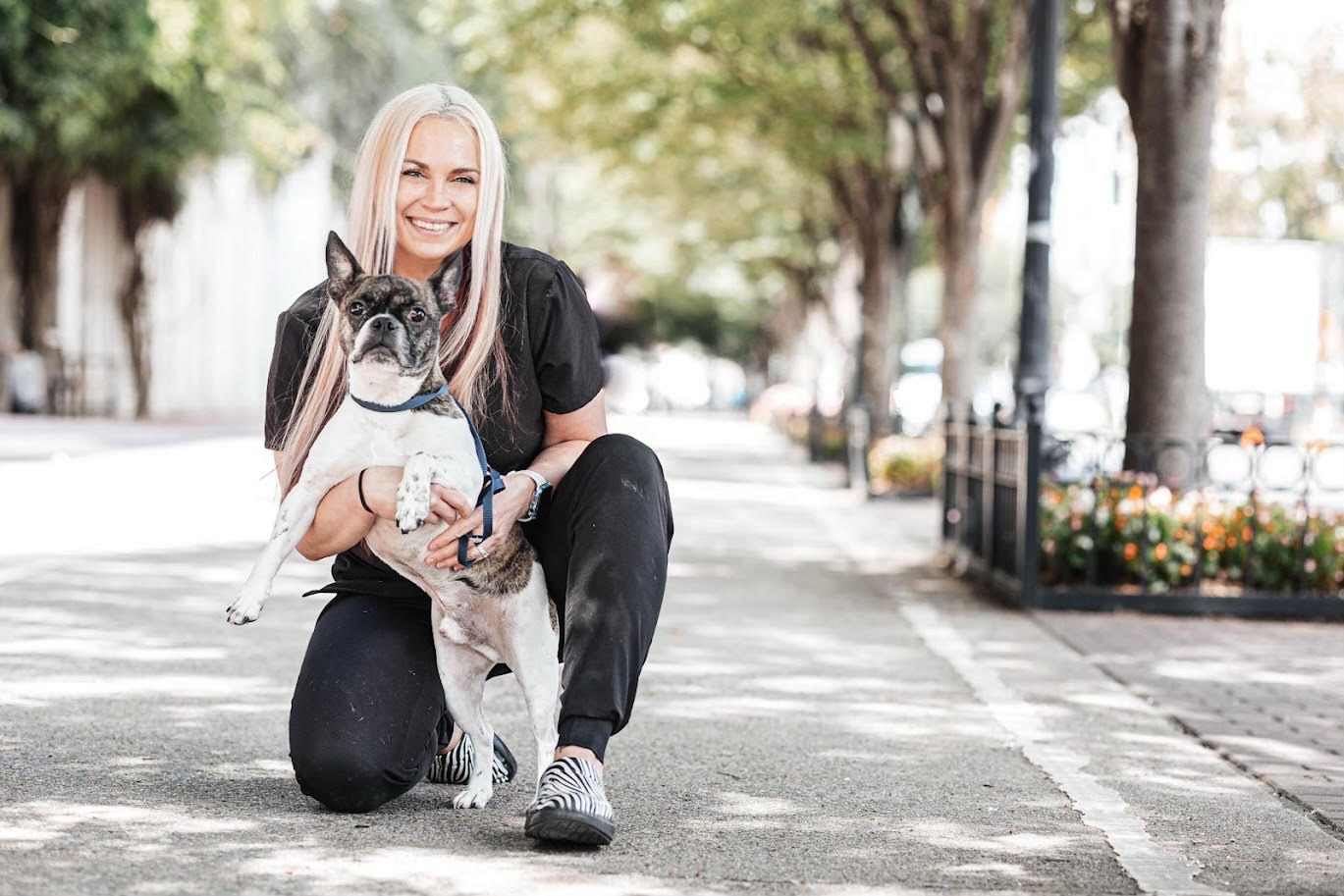 Tara Walker, practice manager, kneeling beside a dog